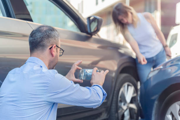 Man Taking a Picture at a Car Accident Scene