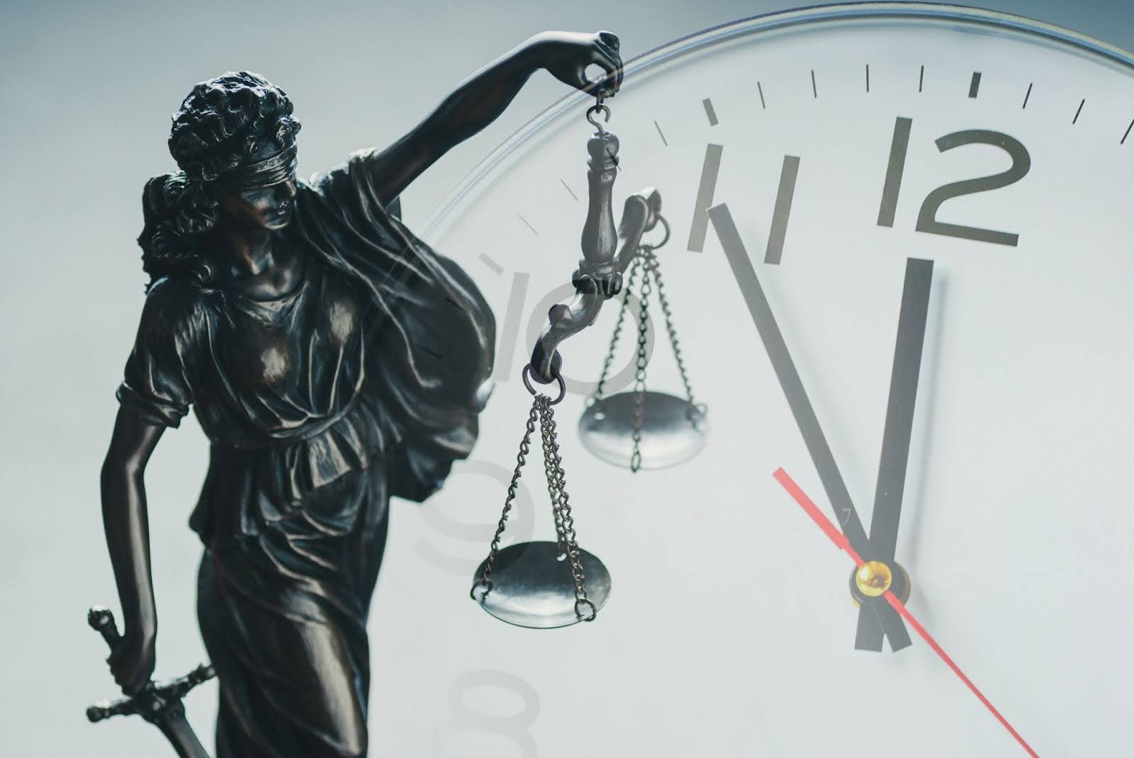 justice statue in front of clock